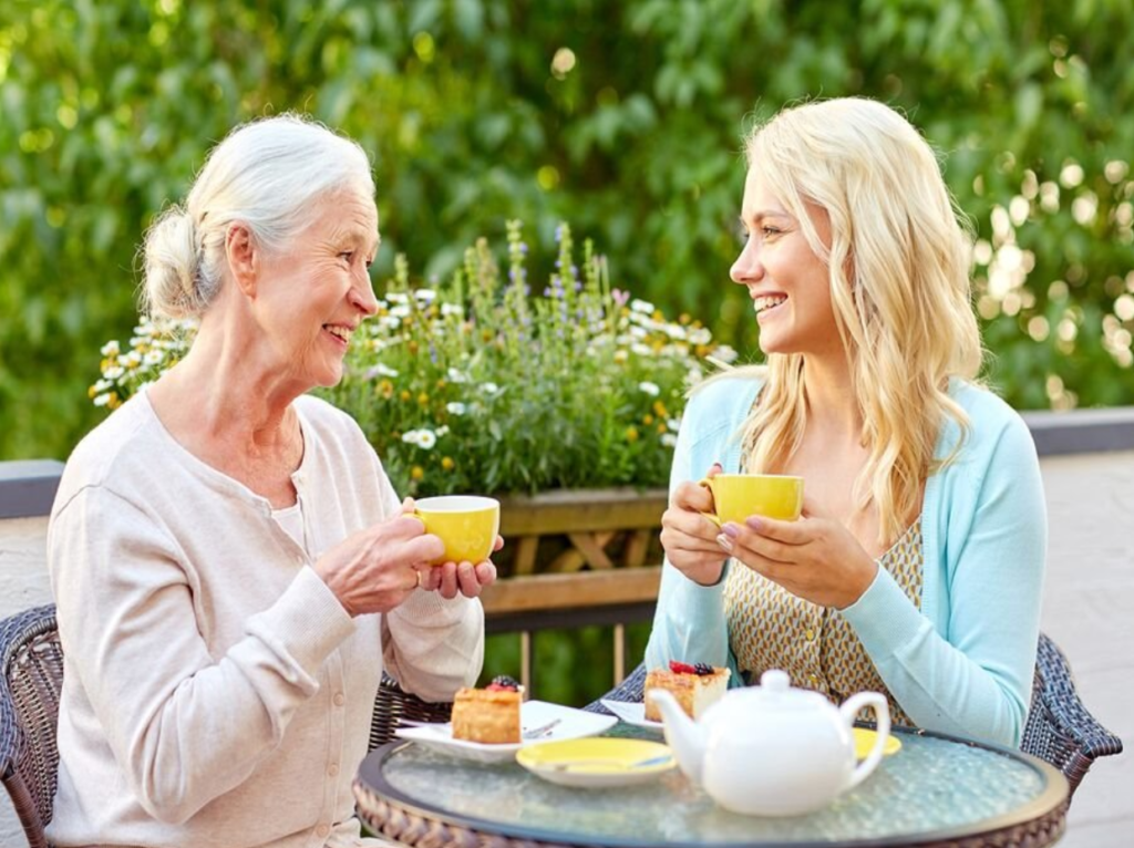 Caregiver Agency caregiver and Elderly woman enjoying tea.